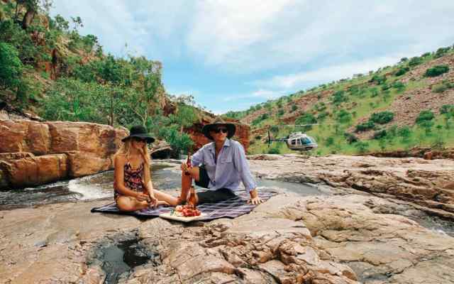 two people sitting on a gorge having a picnic in the Kimberly's in WA